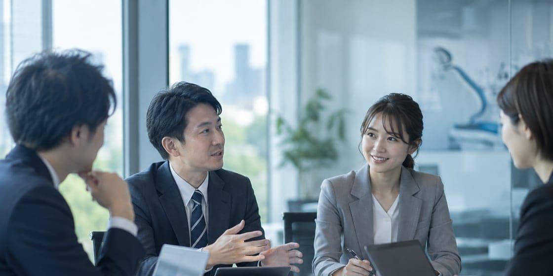 オフィスの会議室で打ち合わせをする経営戦略研究所の担当者